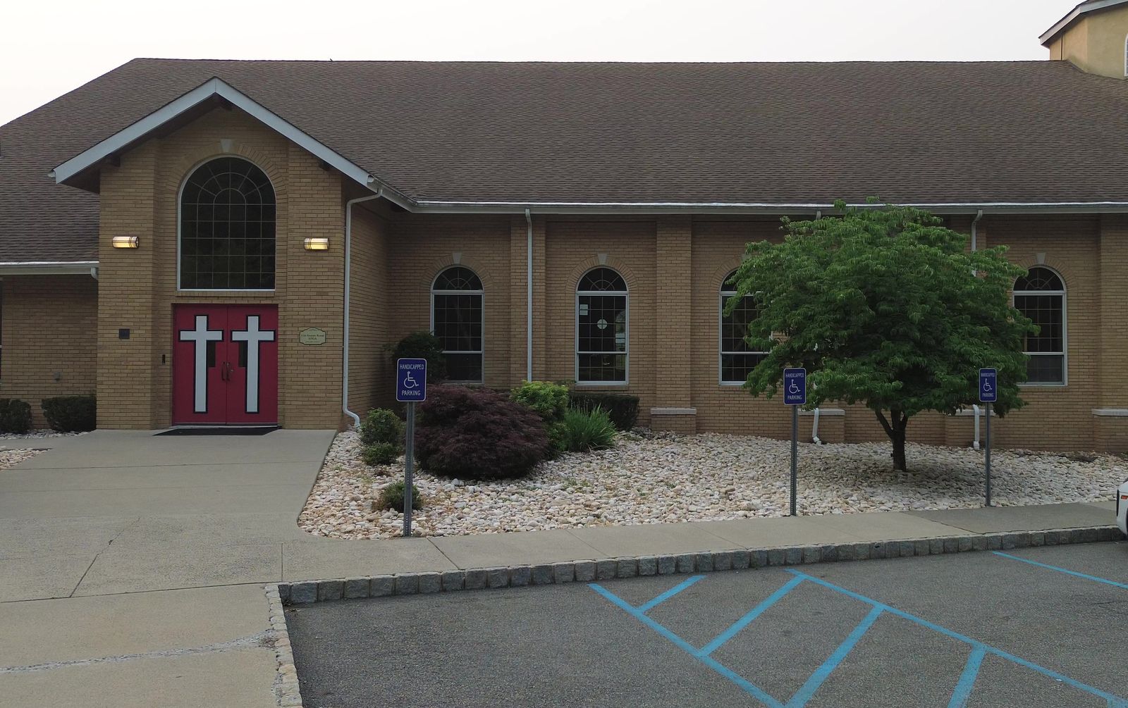 The front entrance of the church building, with red doors marked by white crosses