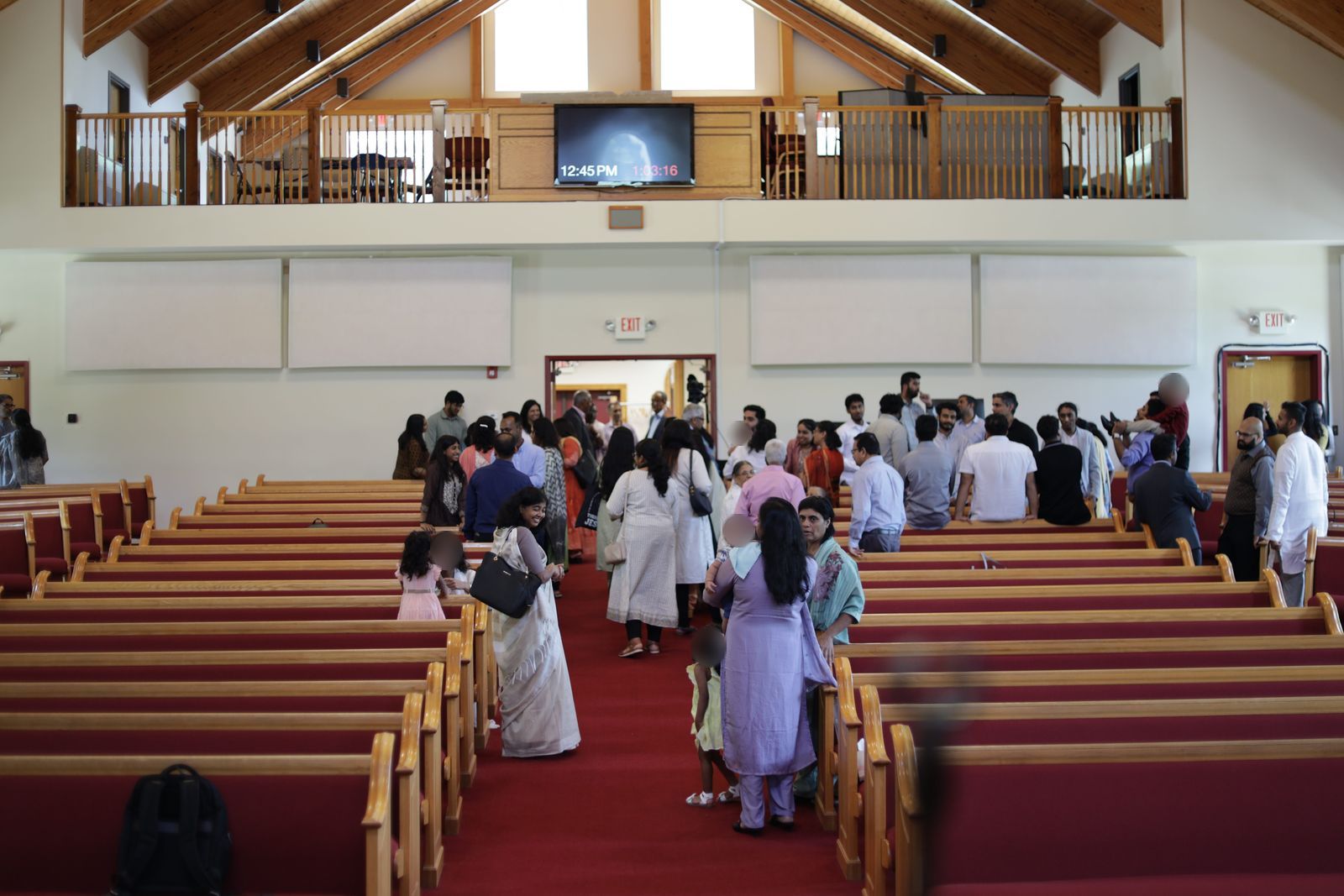 Members of the congregation greeting one another in the sanctuary after a Sunday service
