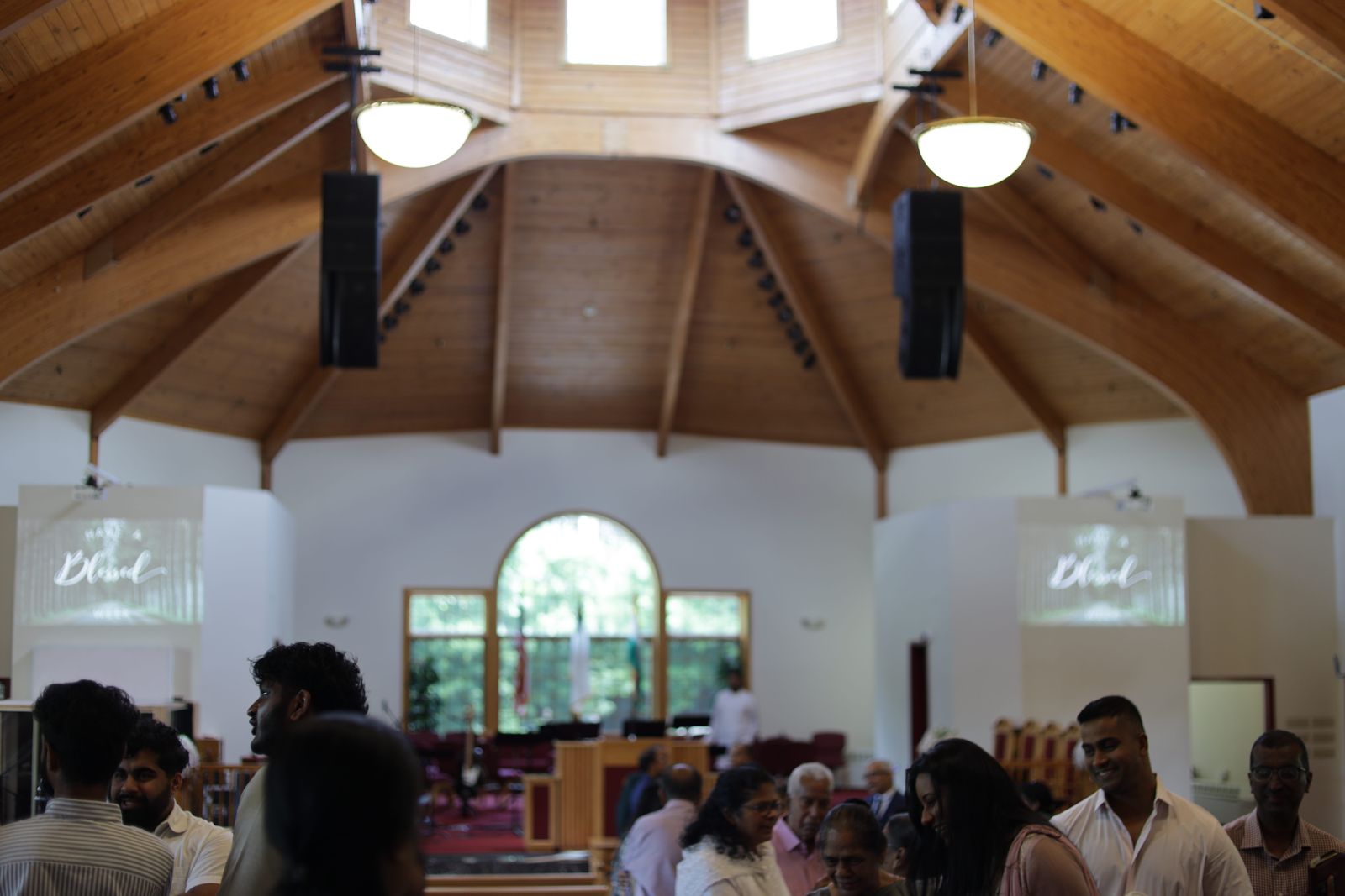 People talking together beneath the wooden ceiling of the sanctuary